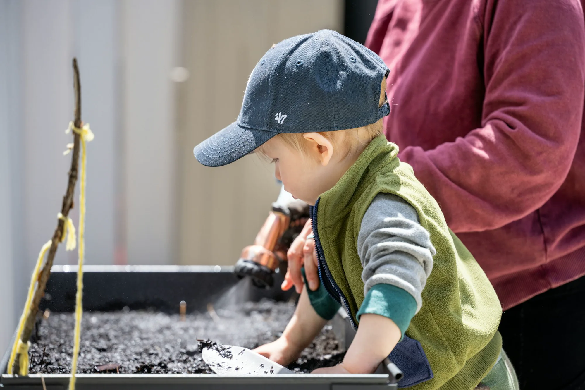 A parent and child working together in their garden
