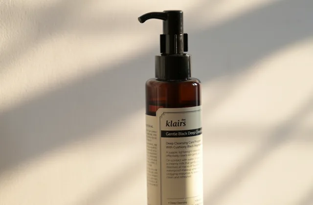 Amber bottle of skincare cleansing oil standing on a light surface